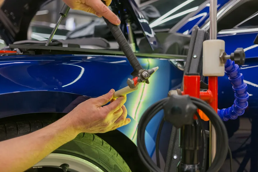 Paintless dent repair tools on a car door